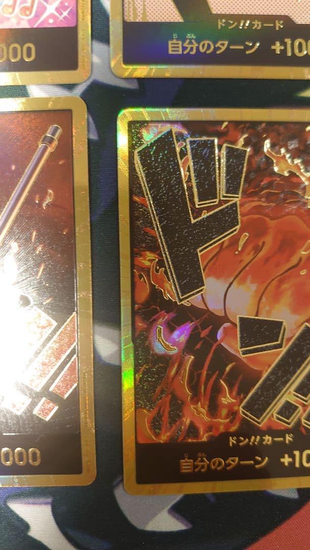 One Piece Card Game cards featuring Sabo, Luffy, Uta, and Akainu with gold borders in protective sleeve