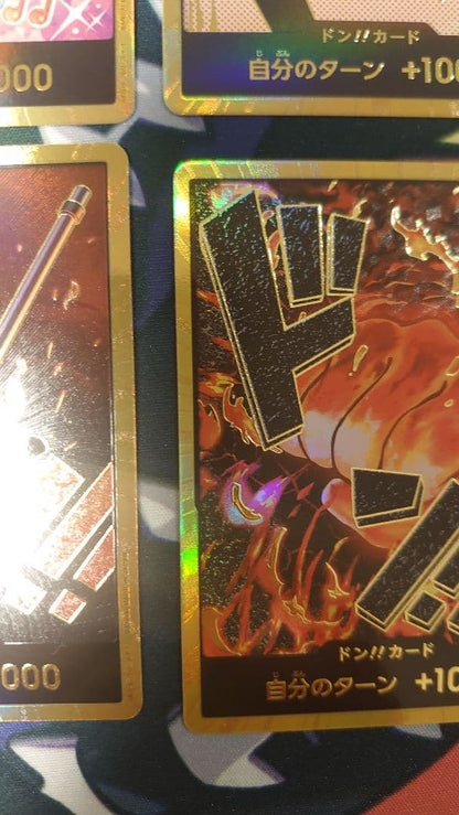 One Piece Card Game cards featuring Sabo, Luffy, Uta, and Akainu with gold borders in protective sleeve