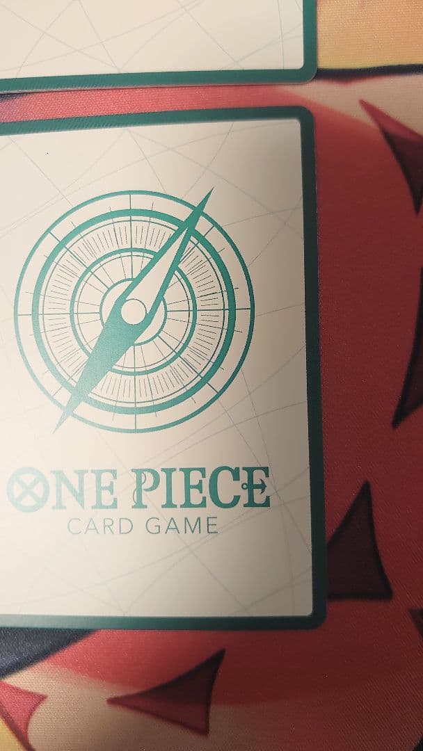 One Piece Card Game cards featuring Sabo, Luffy, Uta, and Akainu with gold borders in protective sleeve