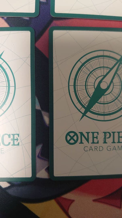 One Piece Card Game cards featuring Sabo, Luffy, Uta, and Akainu with gold borders in protective sleeve