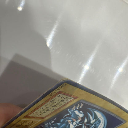 Yugioh Blue-Eyes White Dragon Ultra Rare Early Edition trading card showing signs of use and corner creases