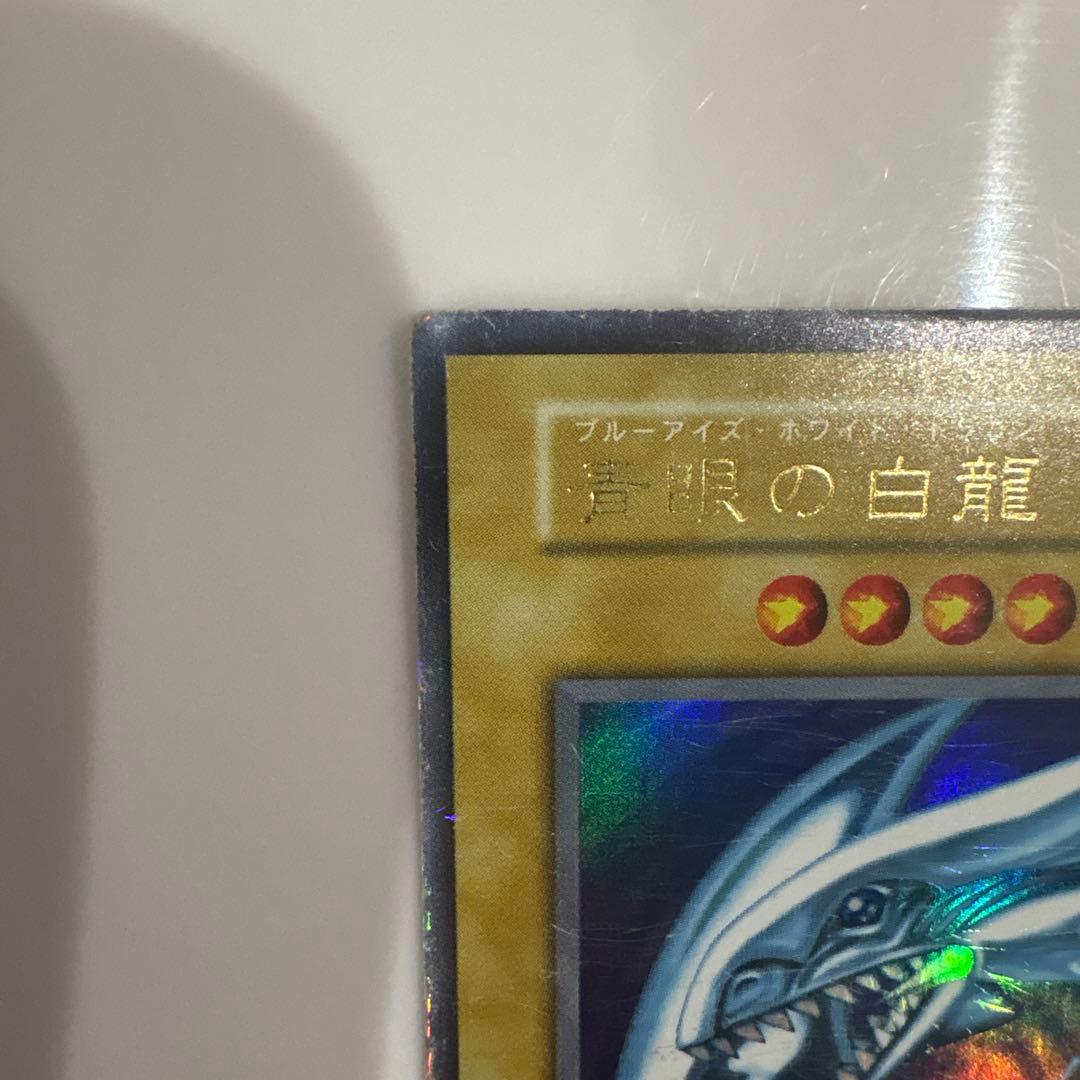 Yugioh Blue-Eyes White Dragon Ultra Rare Early Edition trading card showing signs of use and corner creases