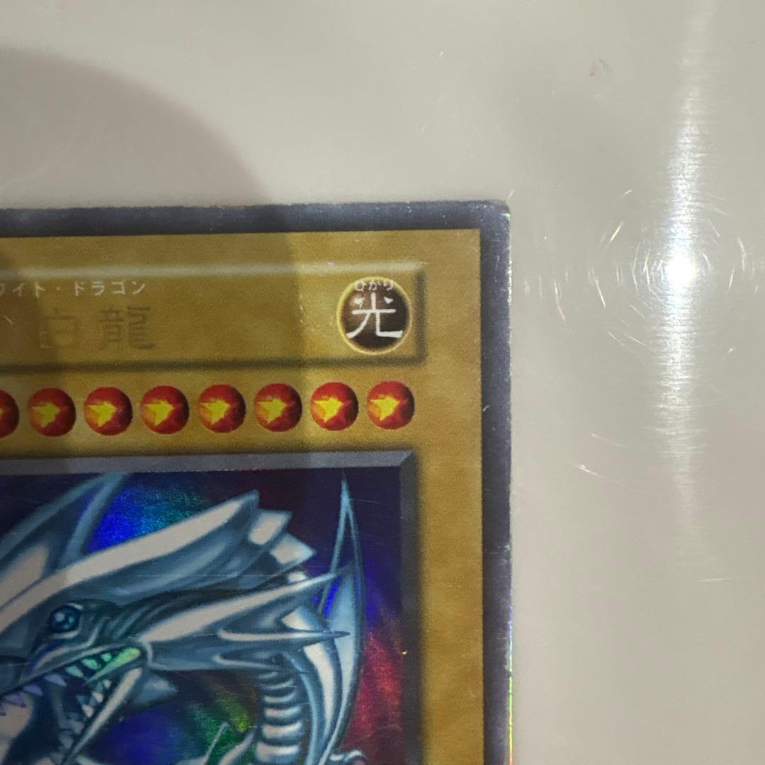 Yugioh Blue-Eyes White Dragon Ultra Rare Early Edition trading card showing signs of use and corner creases