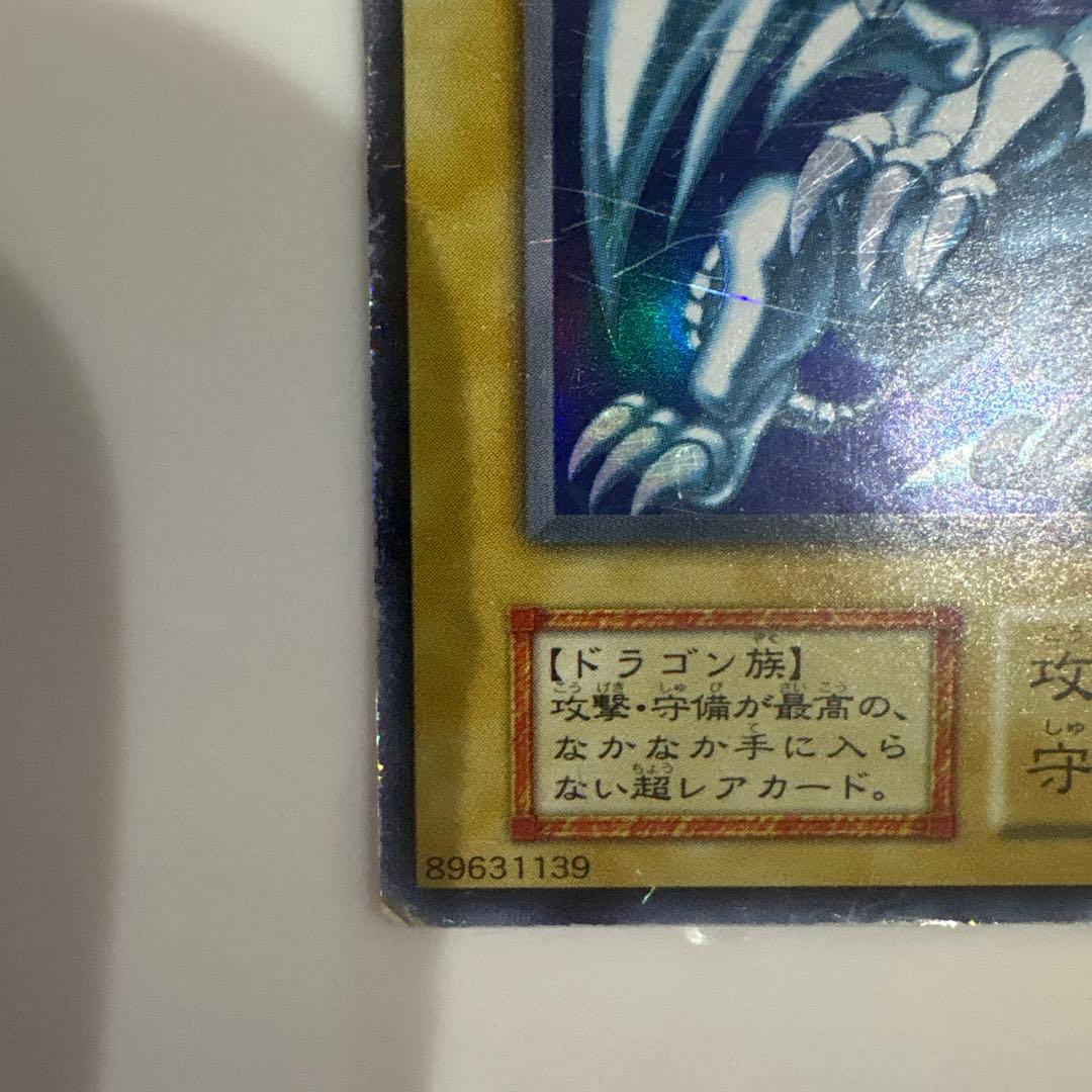 Yugioh Blue-Eyes White Dragon Ultra Rare Early Edition trading card showing signs of use and corner creases