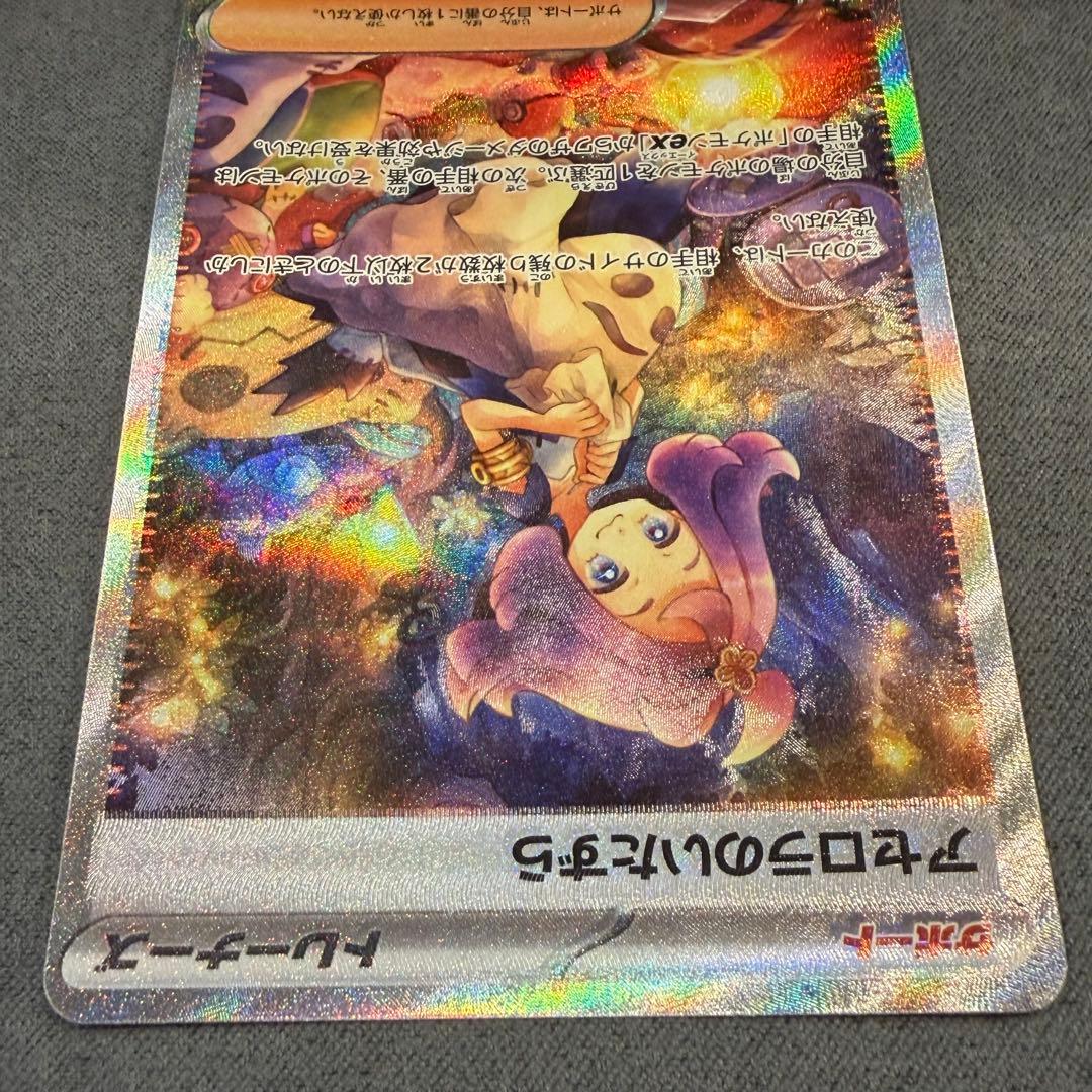 Asucola's Prank SAR 090/063 support card from Scarlet & Violet series with holo misalignment in bottom right corner