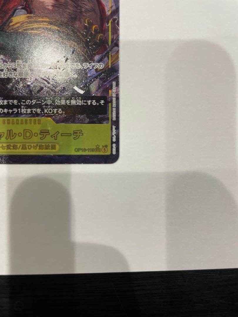 One Piece Marshall D. Teach collectible card in protective sleeve and case showing minor wear