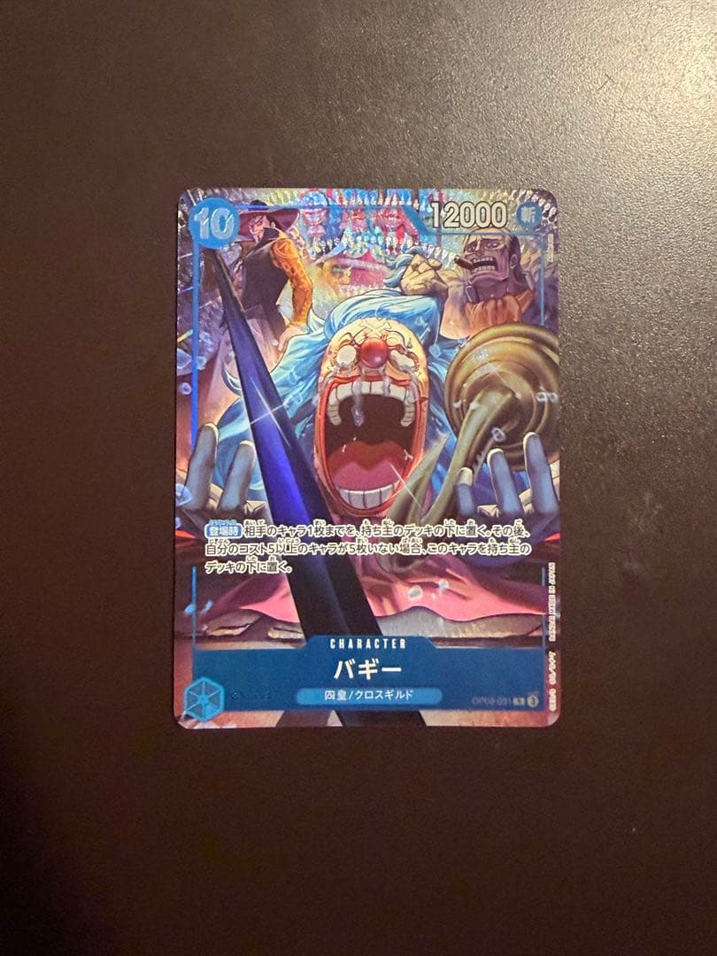 One Piece Buggy Character Card OP09-051 in protective sleeve with no visible scratches or stains