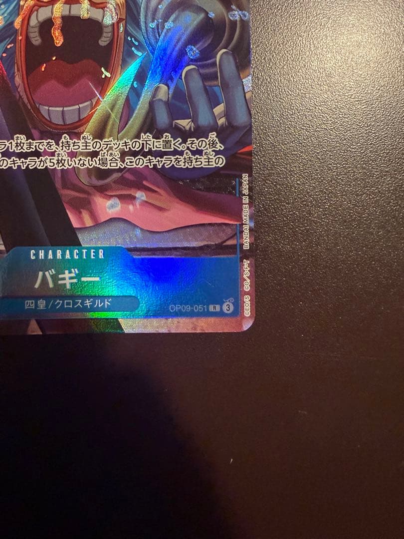 One Piece Buggy Character Card OP09-051 in protective sleeve with no visible scratches or stains