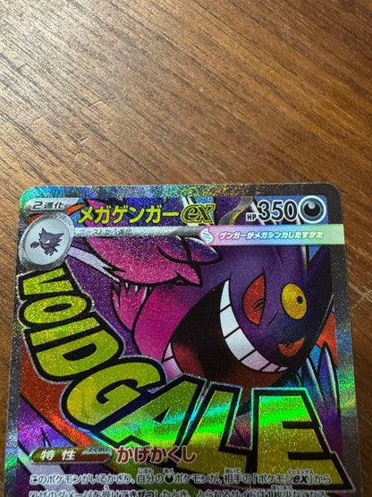 Pokemon card set featuring Mega Charizard X ex MA and Mega Gengar ex MA cards in protective sleeves