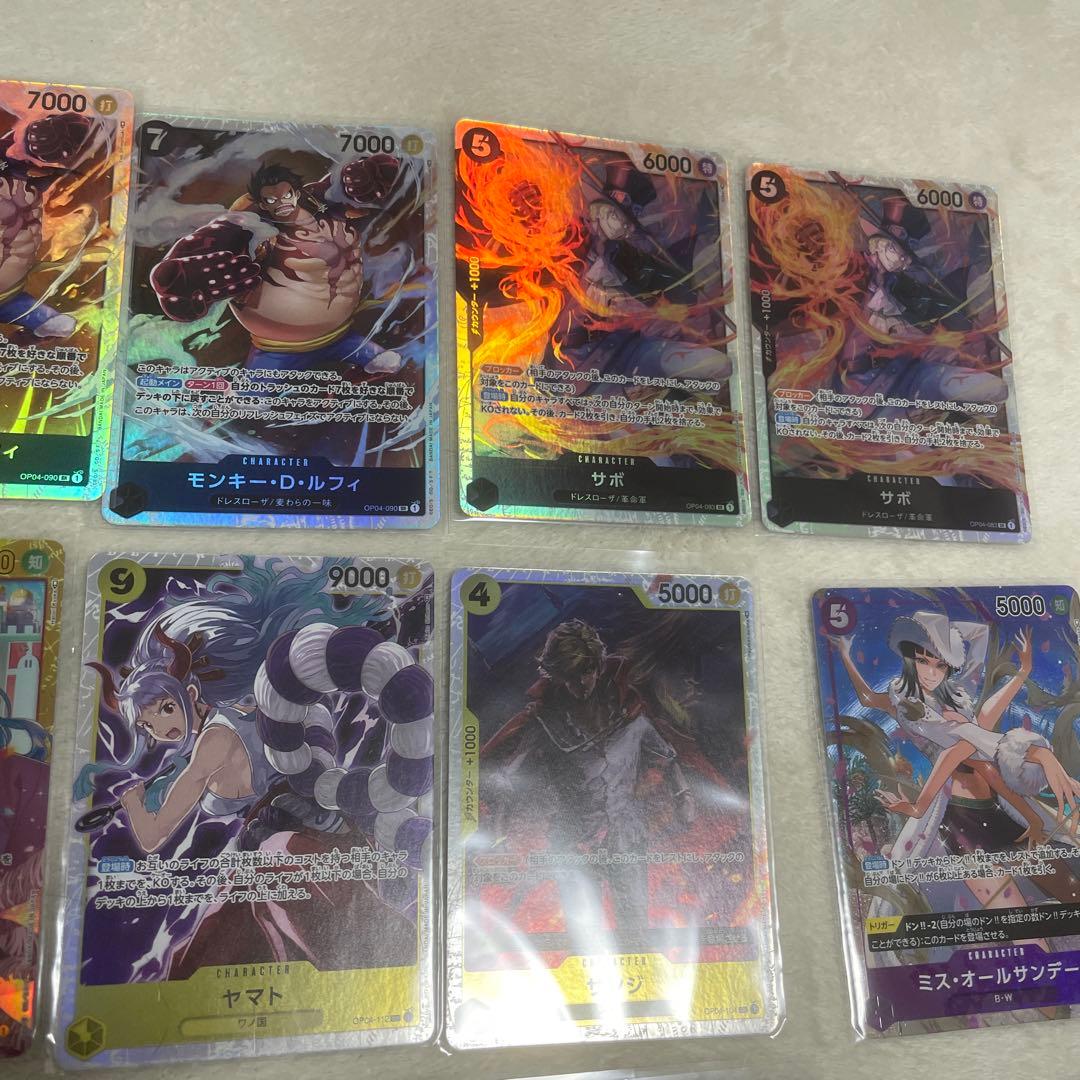 One Piece card set with Monkey D. Luffy SR, Sabo SR, Shanks R, and other rare cards in protective sleeves