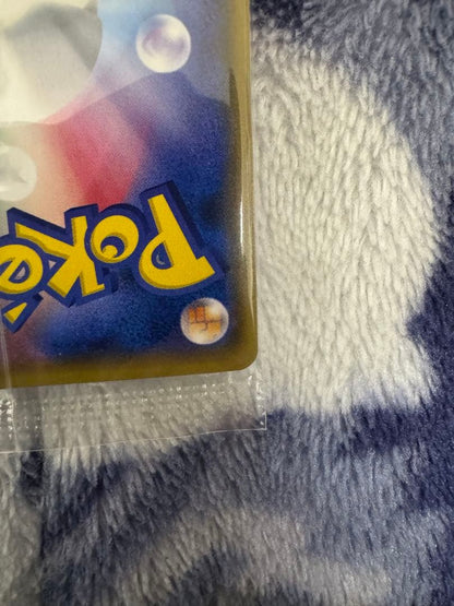Bandai Pokemon Card Lele Promo from Japan import sealed in a loader, displayed on a dark background