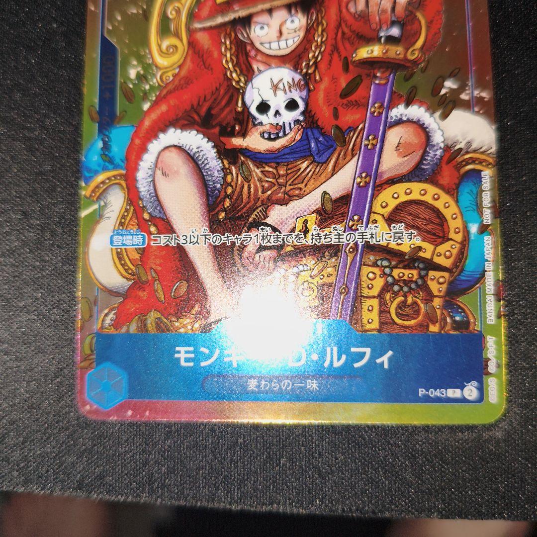 One Piece Monkey D. Luffy P-043 collectible card showing front with minor scratches and paint peeling on back