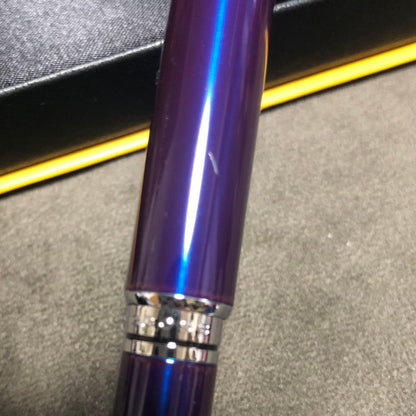 Blue metal-bodied Brand Crossball ballpoint pen with silver tip and visible scratch on glossy surface