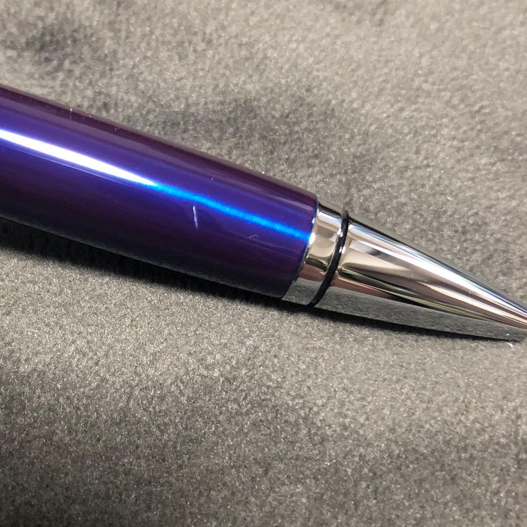 Blue metal-bodied Brand Crossball ballpoint pen with silver tip and visible scratch on glossy surface