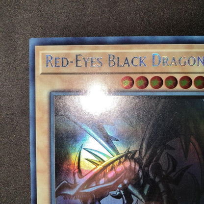 Yugioh Red-Eyes Black Dragon English Ghost Rare Foil card with image shifted lower left and white fog mark on back
