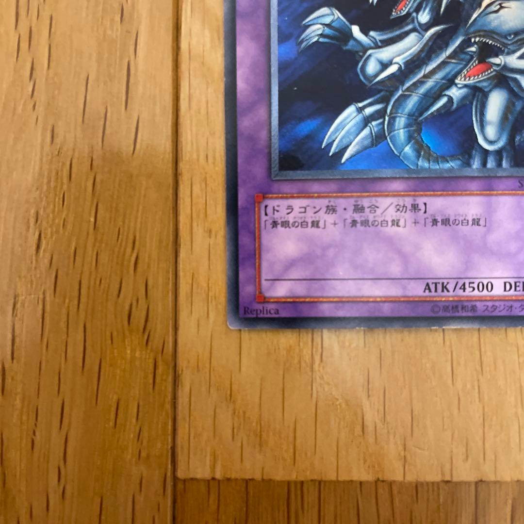 Yu-Gi-Oh Blue-Eyes Ultimate Dragon Ultra Rare SDX-001 card with visible scratches and chipping