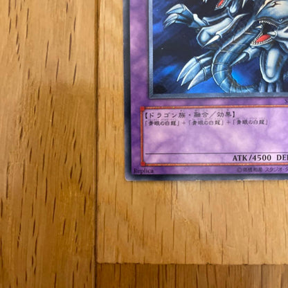 Yu-Gi-Oh Blue-Eyes Ultimate Dragon Ultra Rare SDX-001 card with visible scratches and chipping