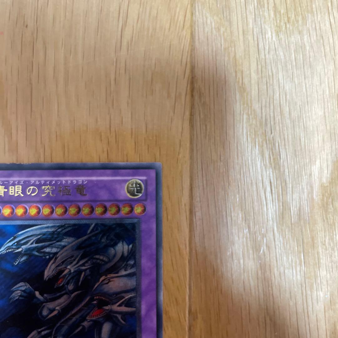Yu-Gi-Oh Blue-Eyes Ultimate Dragon Ultra Rare SDX-001 card with visible scratches and chipping
