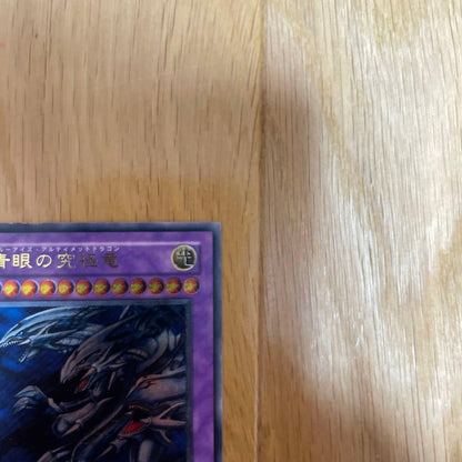 Yu-Gi-Oh Blue-Eyes Ultimate Dragon Ultra Rare SDX-001 card with visible scratches and chipping
