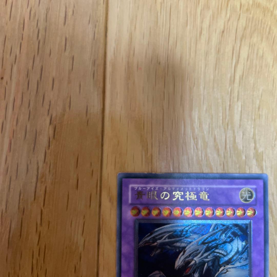 Yu-Gi-Oh Blue-Eyes Ultimate Dragon Ultra Rare SDX-001 card with visible scratches and chipping