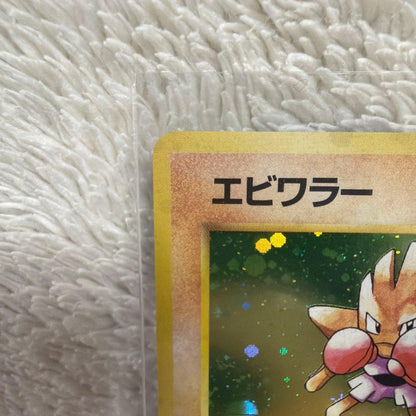 Pokemon Series One Ekans trading card with holo wrap outside illustration in used condition