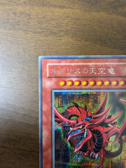 Osiris Sky Dragon God Card G4-01 with visible corner scratches stored in protective sleeve