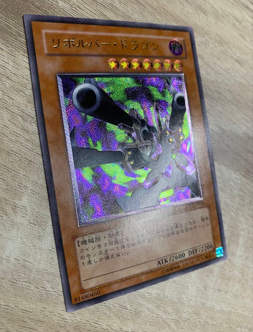 Vintage Yu-Gi-Oh Revolvedragon relief card in retro style stored in a filing system