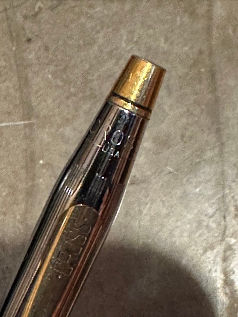Cross ballpoint pen with silver and gold body, dark blue ink, made in USA, showing signs of use