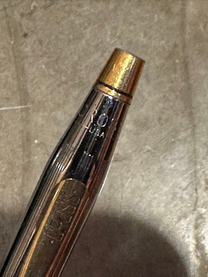 Cross ballpoint pen with silver and gold body, dark blue ink, made in USA, showing signs of use