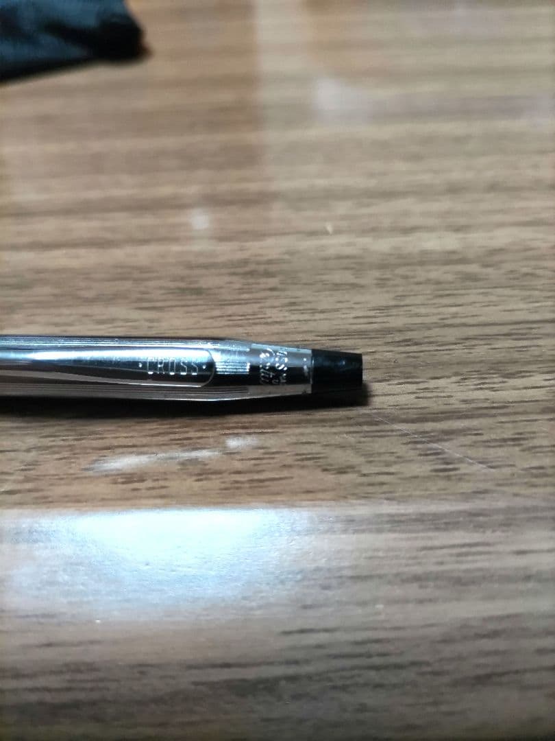 Cross ballpoint pen with silver body and detailed knurled grip, featuring blue ink
