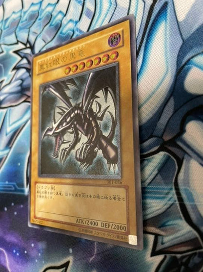 Yugioh Red-Eyes Black Dragon Relief vintage trading card with minor wear, shown in protective sleeve