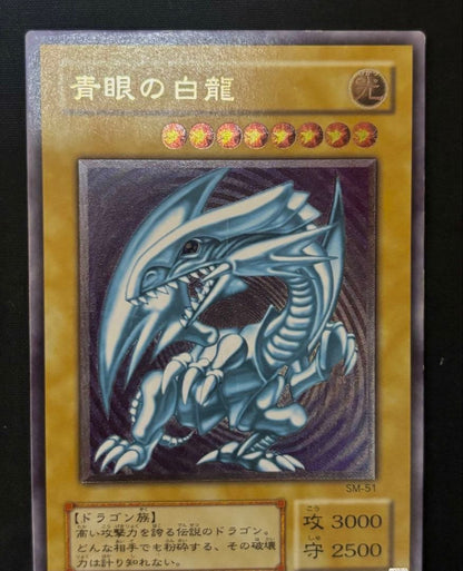 Used Yugioh Blue-Eyes White Dragon Ultra Rare SM-51 trading card from Japan with visible scratches and damage