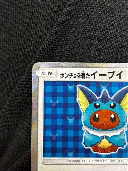 Pokemon promotional card featuring Eevee wearing a poncho with slight crease and small chip