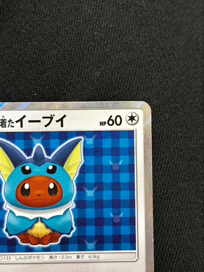 Pokemon promotional card featuring Eevee wearing a poncho with slight crease and small chip