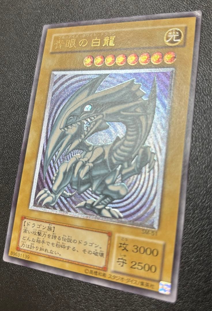 Blue-Eyes White Dragon relief card with 3000 attack power showing slight crease in upper right corner