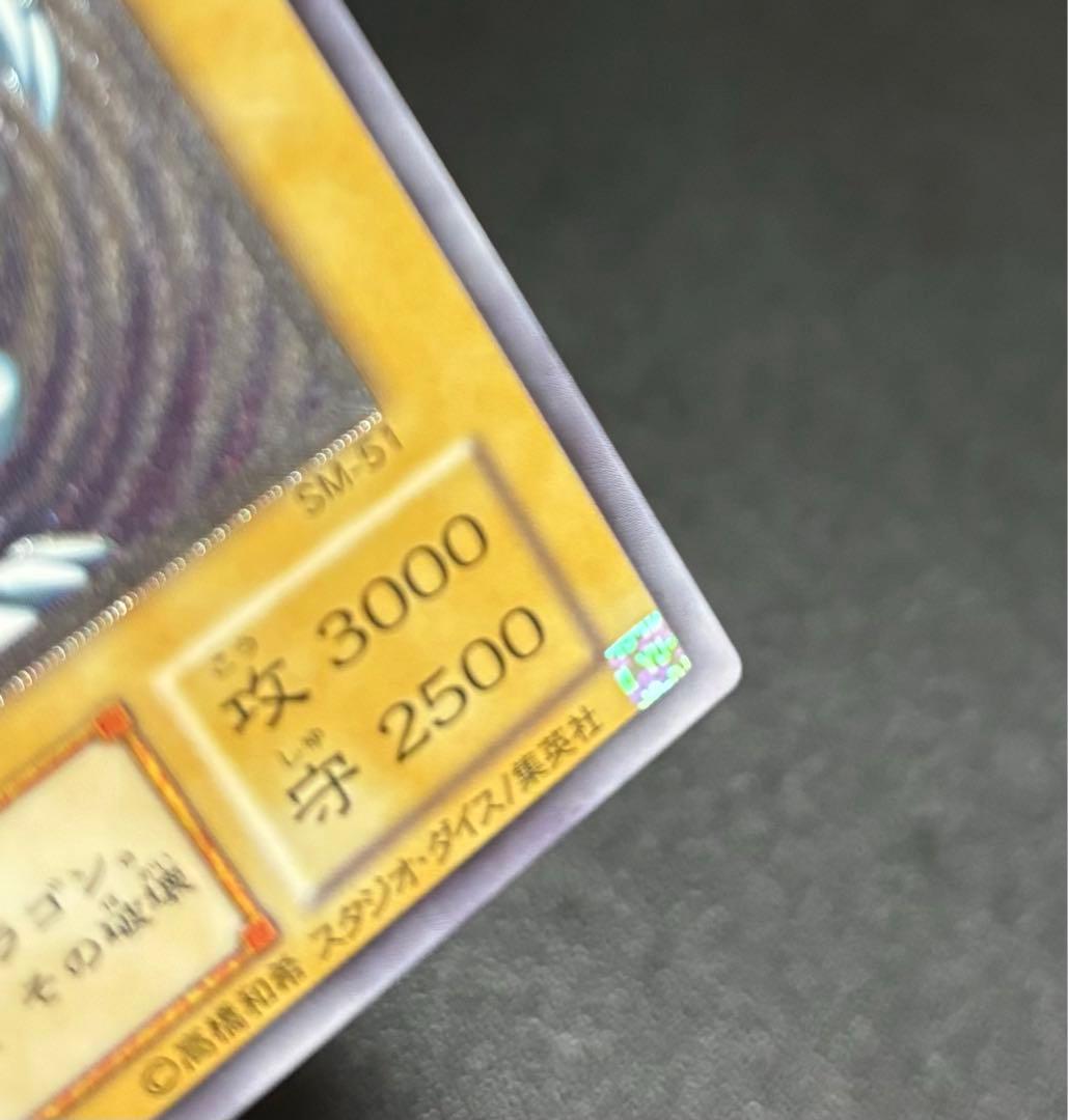 Blue-Eyes White Dragon relief card with 3000 attack power showing slight crease in upper right corner