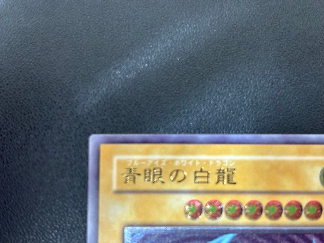 Blue-Eyes White Dragon relief card with 3000 attack power showing slight crease in upper right corner