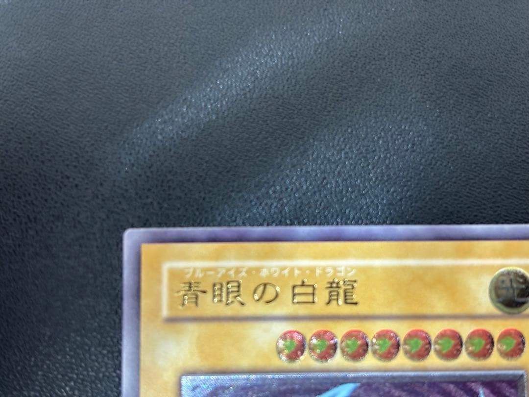 Blue-Eyes White Dragon relief card with 3000 attack power showing slight crease in upper right corner