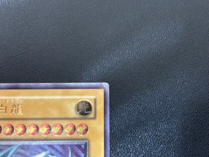 Blue-Eyes White Dragon relief card with 3000 attack power showing slight crease in upper right corner