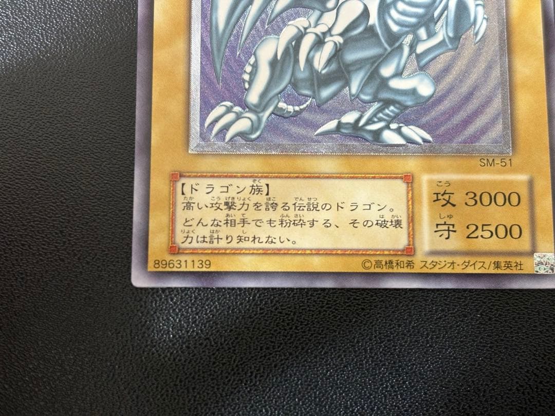 Blue-Eyes White Dragon relief card with 3000 attack power showing slight crease in upper right corner