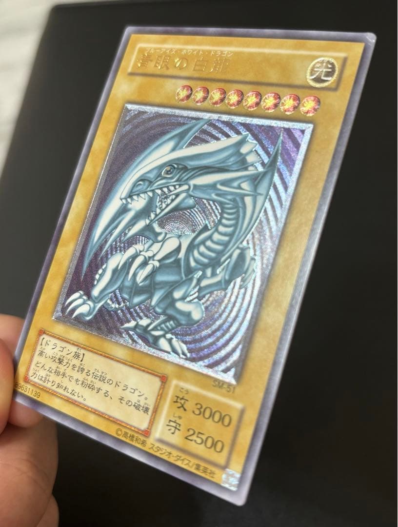Blue-Eyes White Dragon relief card with 3000 attack power showing slight crease in upper right corner