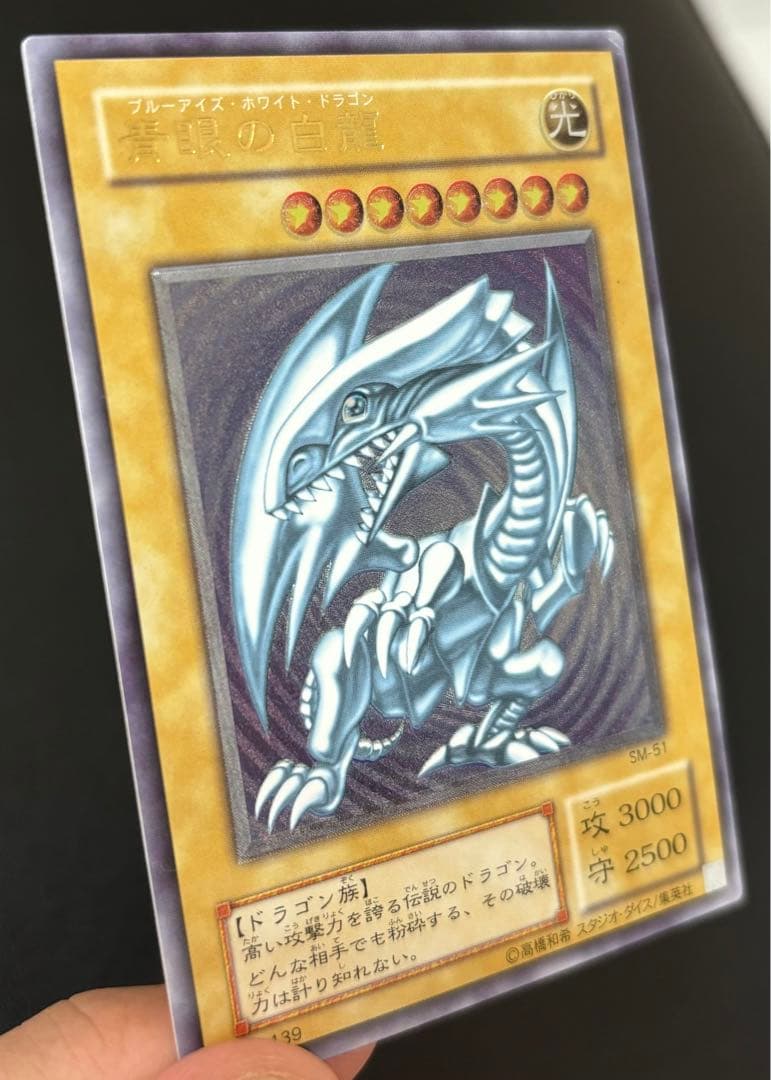 Blue-Eyes White Dragon relief card with 3000 attack power showing slight crease in upper right corner