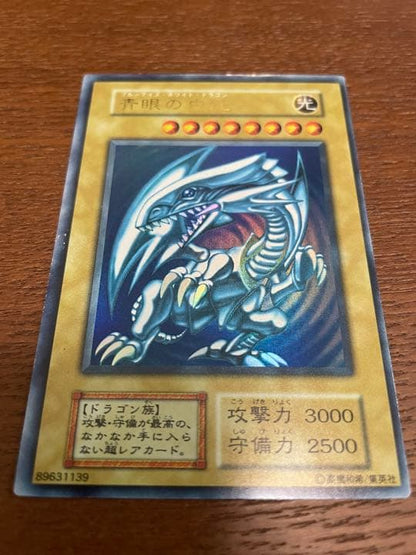 Yu-Gi-Oh Blue-Eyes White Dragon Initial Ultra Rare trading card with minor surface scratches
