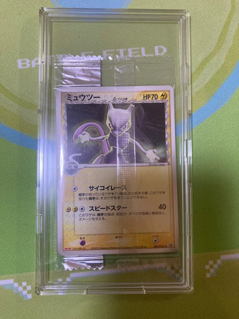 Unopened Meiji Mewtwo Delta Species 107/PCG-P Japanese promo collectible card with visible packaging wrinkles
