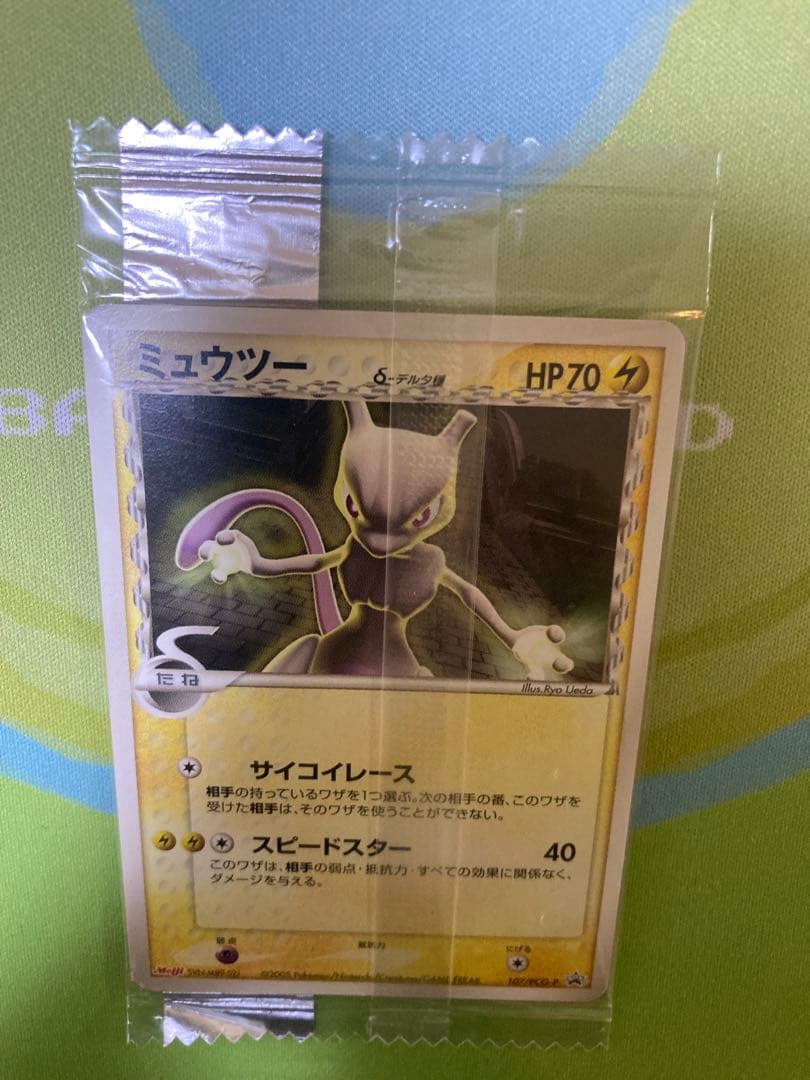Unopened Meiji Mewtwo Delta Species 107/PCG-P Japanese promo collectible card with visible packaging wrinkles