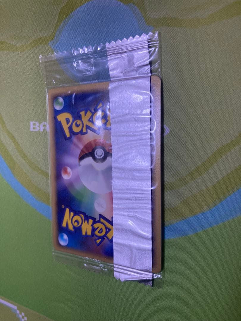 Unopened Meiji Mewtwo Delta Species 107/PCG-P Japanese promo collectible card with visible packaging wrinkles