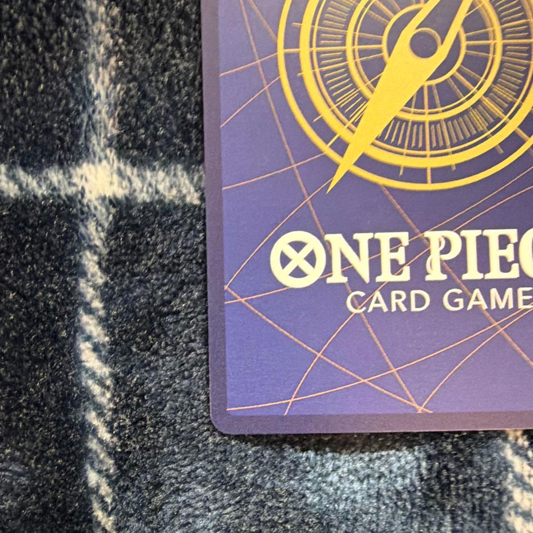 Used One Piece Card Game Nami R OP06-101 promotional card showing minor scratches and stored in protective sleeve