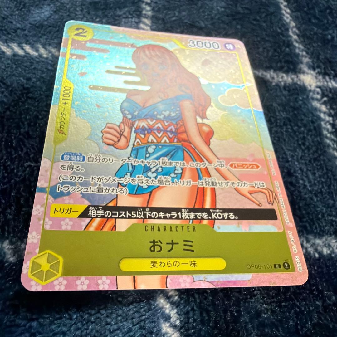 Used One Piece Card Game Nami R OP06-101 promotional card showing minor scratches and stored in protective sleeve