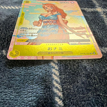 Used One Piece Card Game Nami R OP06-101 promotional card showing minor scratches and stored in protective sleeve