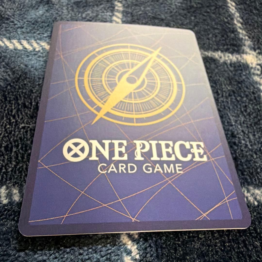 Used One Piece Card Game Nami R OP06-101 promotional card showing minor scratches and stored in protective sleeve